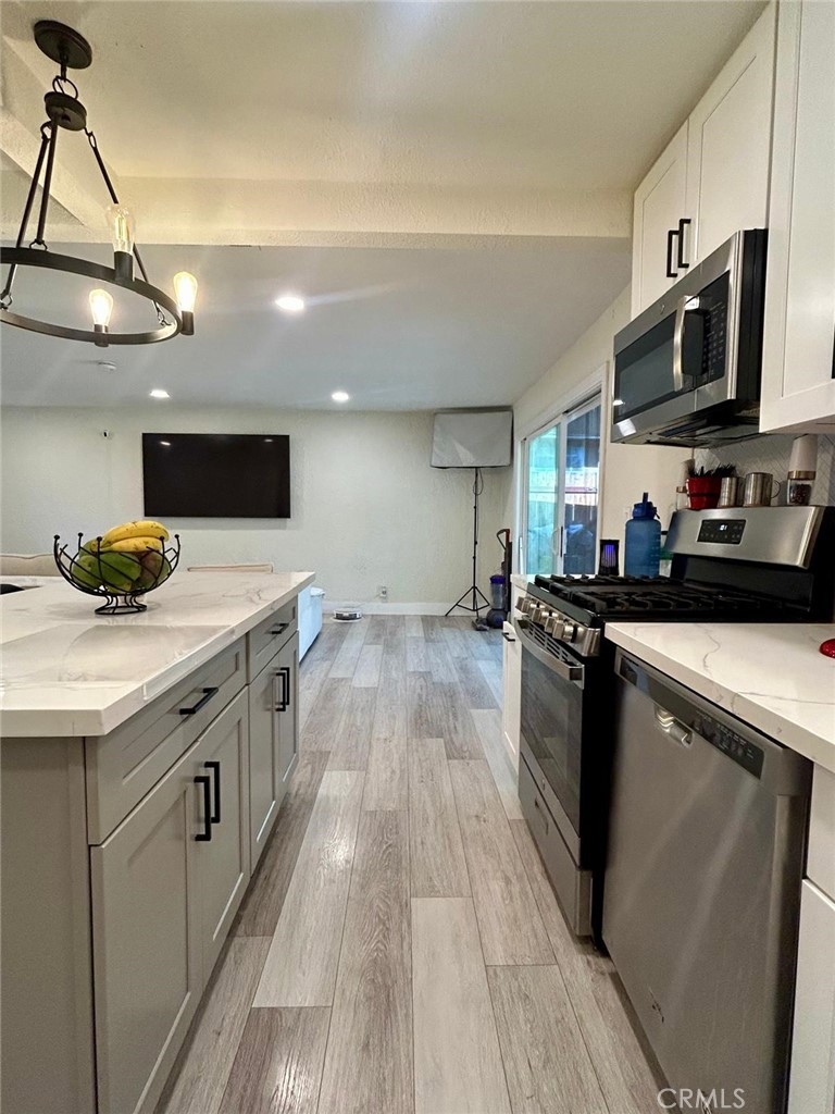 250 Stephens Avenue Riverside, CA 92501 - Photo 7 of 16 a kitchen with stainless steel appliances granite countertop a sink a stove and a wooden floors