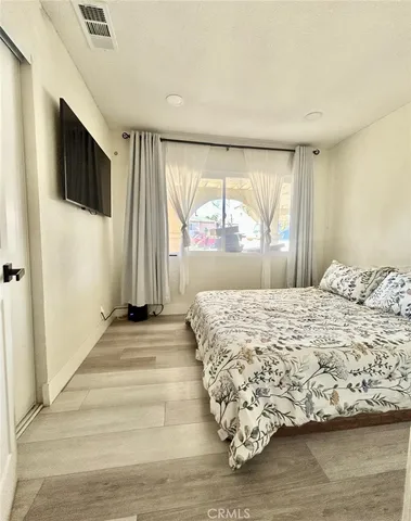 a bedroom with a bed and wooden floor