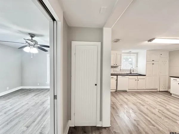 a view of a livingroom with wooden floor and a ceiling fan