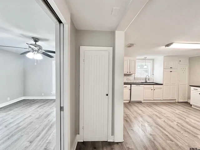 a view of a livingroom with wooden floor and a ceiling fan
