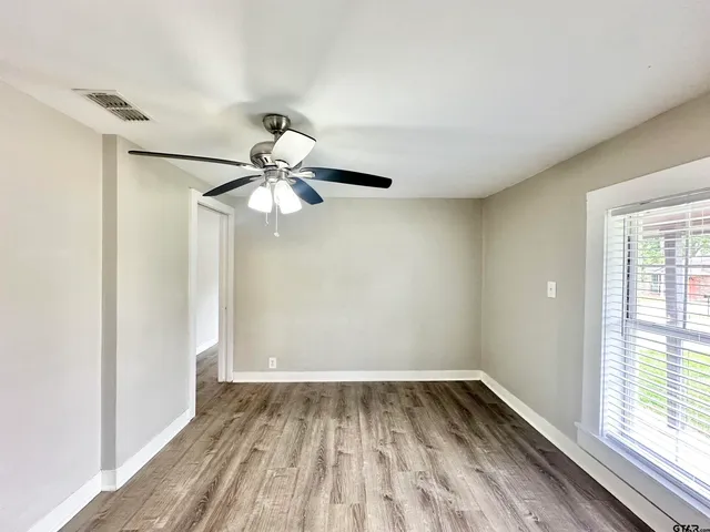 a view of a room with window ceiling fan and wooden floor