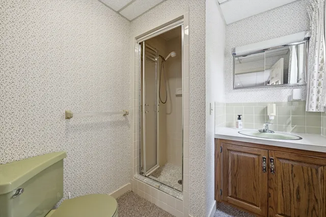 a bathroom with a granite countertop sink toilet and shower
