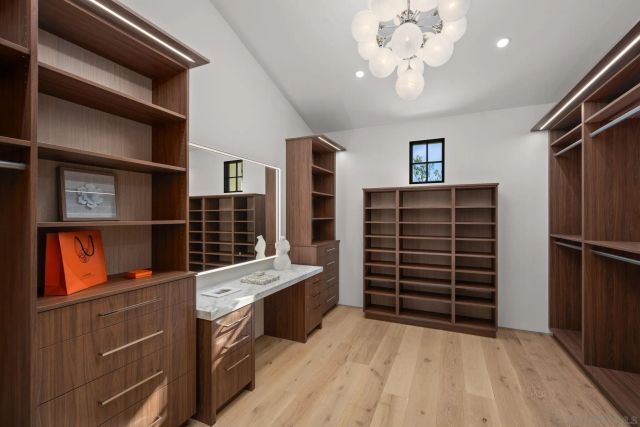 a bedroom with a bed a couch and dresser with wooden floor