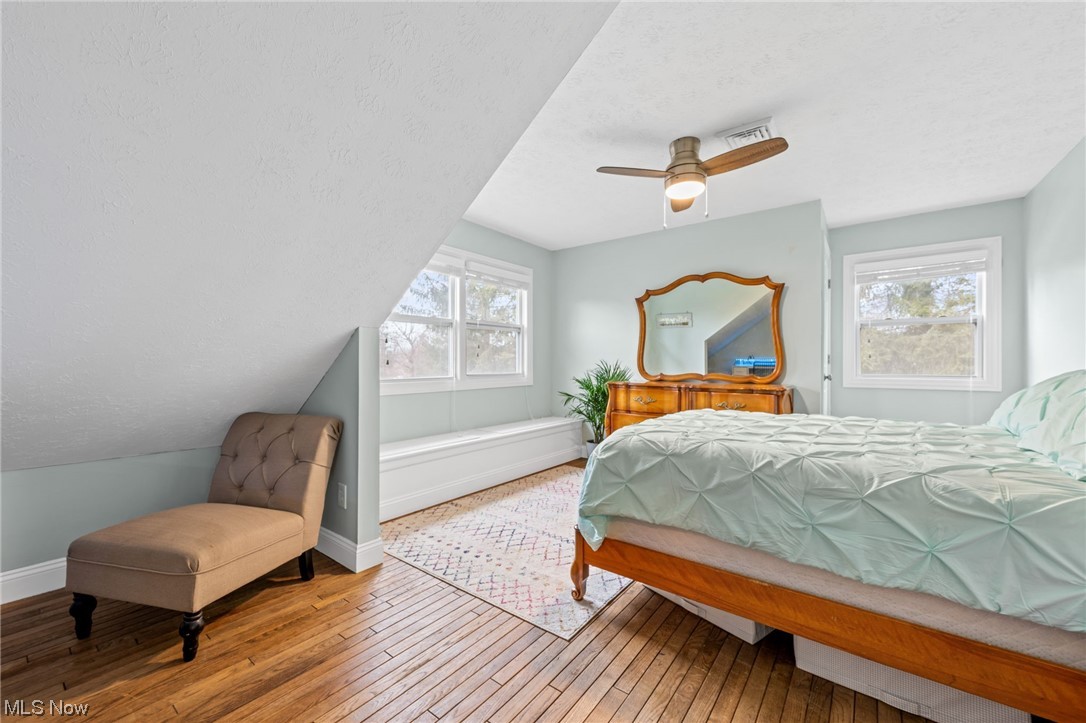 2425 McMackin Road Madison, OH 44057 - Photo 31 of 46 Bedroom with multiple windows, light hardwood / wood-style flooring, and ceiling fan