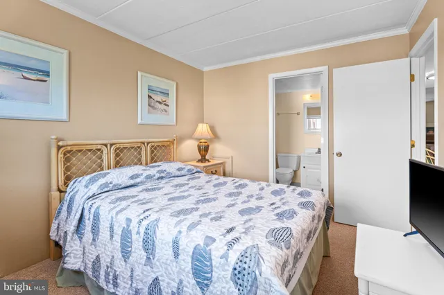 a bedroom with a bed and a flat tv screen on dresser