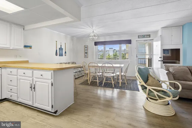 a dining area with furniture a rug and wooden floor