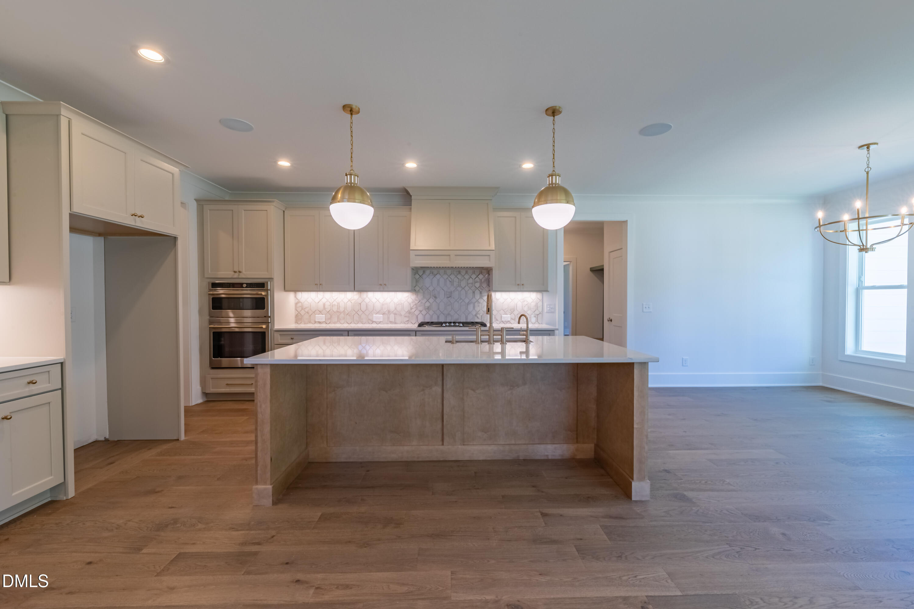 5709 Flowery Mdw Court Wake Forest, NC 27587 - Photo 25 of 69 a large kitchen with kitchen island a sink stainless steel appliances and a fireplace