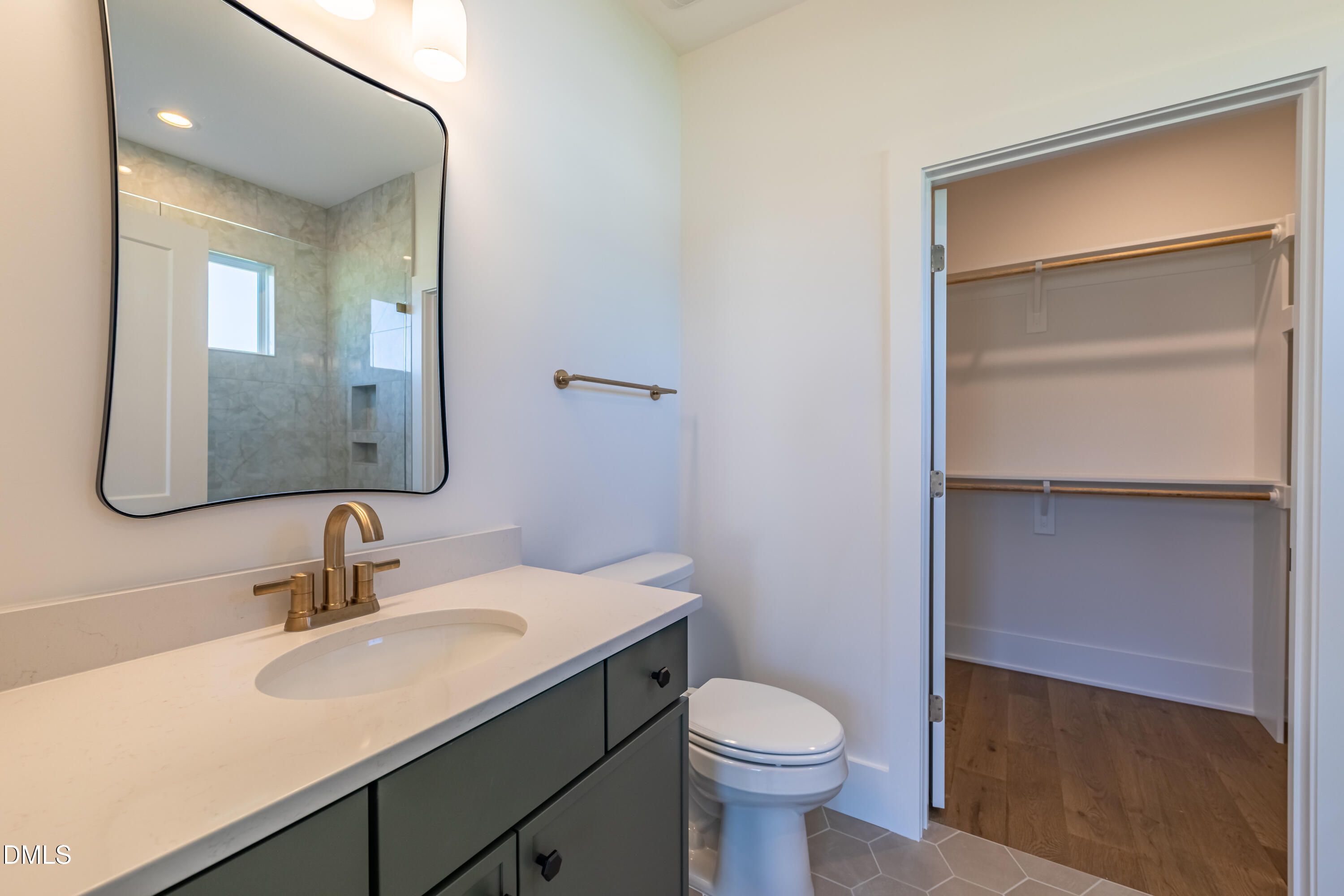 5709 Flowery Mdw Court Wake Forest, NC 27587 - Photo 49 of 69 a bathroom with a sink toilet a mirror and vanity