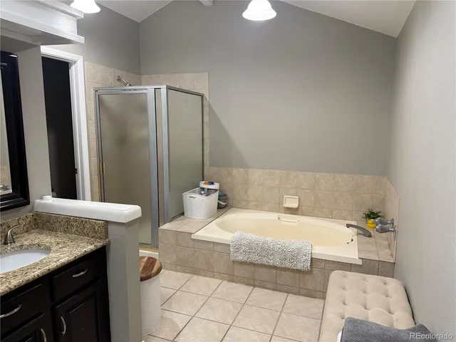 a bathroom with a granite countertop sink and a bathtub