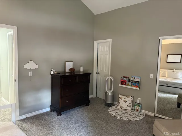 a room with a baby crib and a dresser next to a window