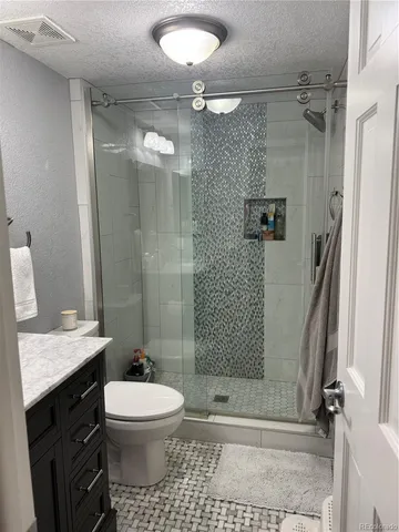 a bathroom with a toilet a sink and shower