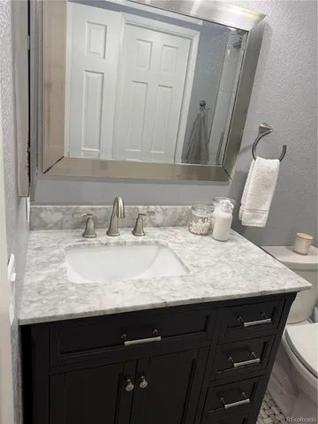 a bathroom with a granite countertop sink and a mirror