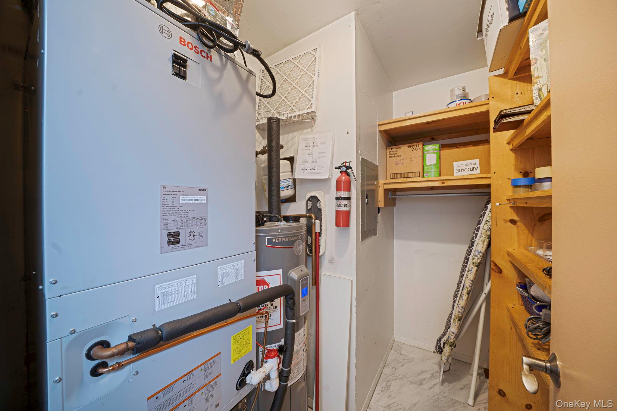 94 Birchwood Road Coram, NY 11727 - Photo 21 of 34 Utility room with newly installed BOSCH HVAC system, RHEEM water heater and plenty of space for storage with shelving built in.