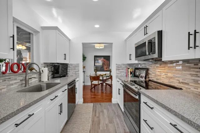 a kitchen with stainless steel appliances granite countertop a sink stove microwave and cabinets