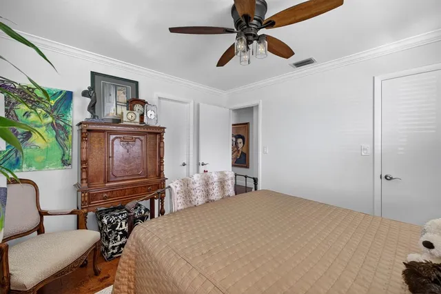 a bedroom with a bed dresser and a chandelier
