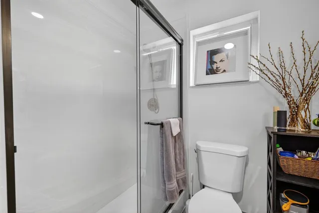 a white toilet sitting next to a bathroom sink and vanity