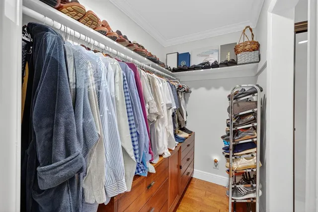 a view of walk in closet with clothes and shoes