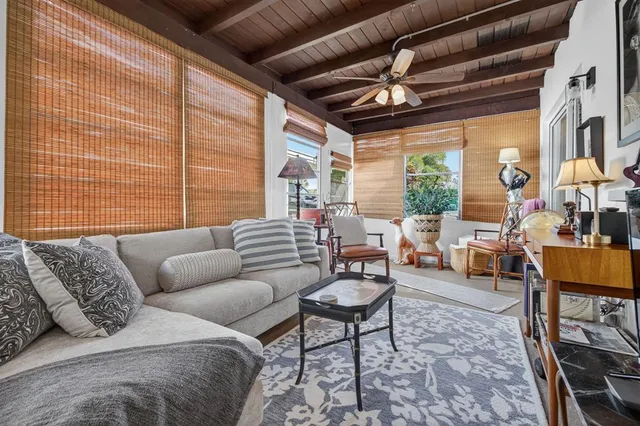 a living room with furniture a chandelier and a floor to ceiling window