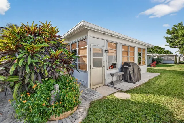 a view of a house with backyard and sitting area