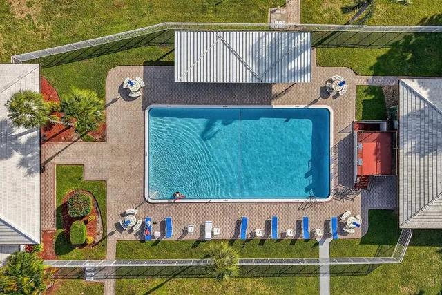 swimming pool view with a garden and seating area