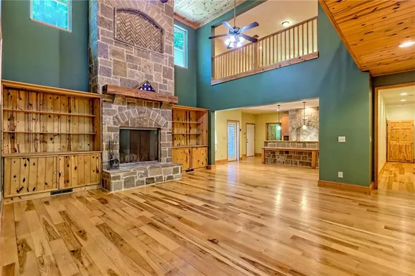 a view of an empty room with wooden floor and windows