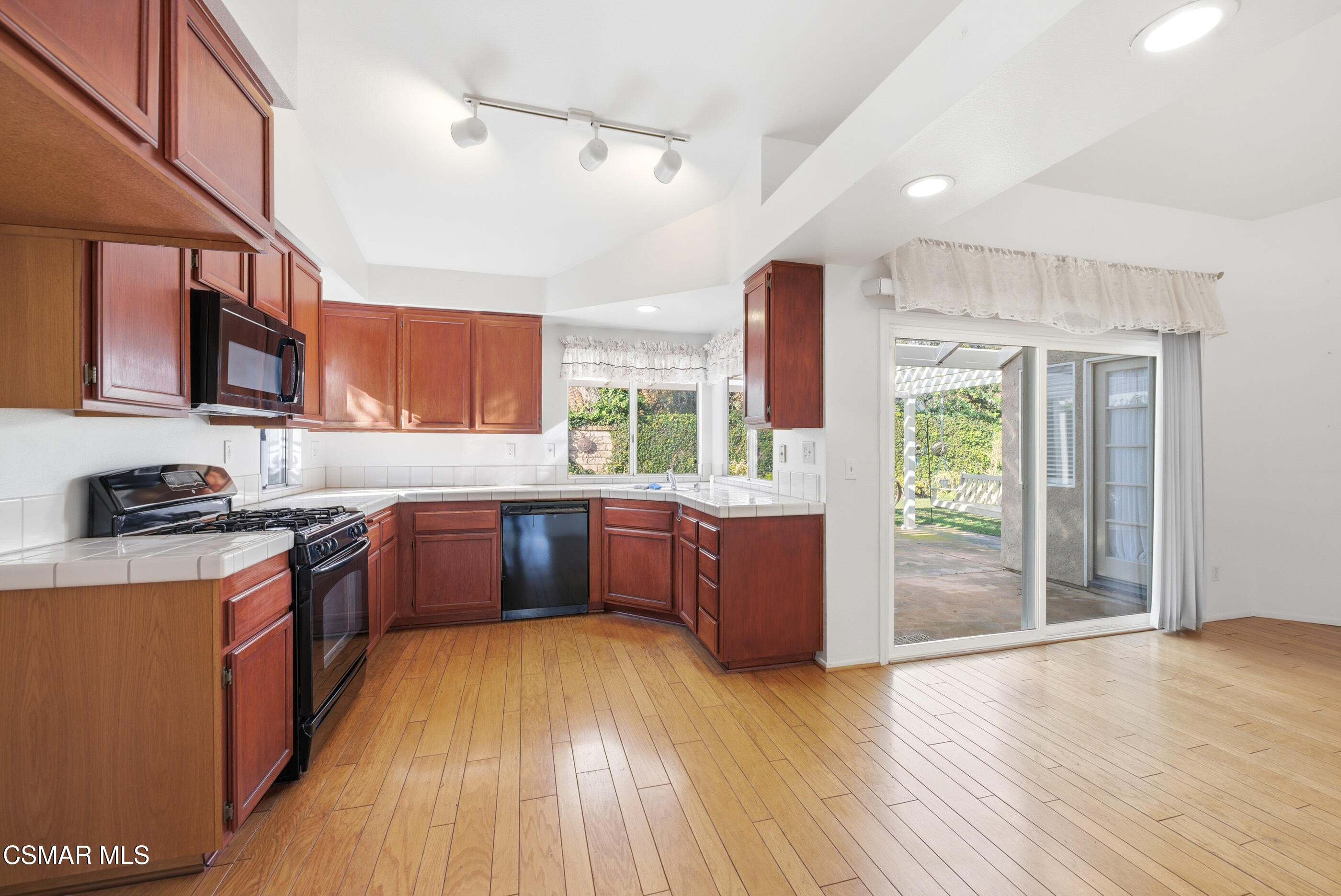 2565 Winthrop Court Simi Valley, CA 93065 - Photo 14 of 37 a large kitchen with stainless steel appliances granite countertop a stove a refrigerator a sink dishwasher and wooden cabinets with wooden floor