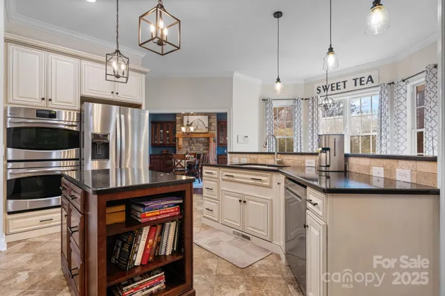 a kitchen with stainless steel appliances granite countertop a stove a sink and a refrigerator