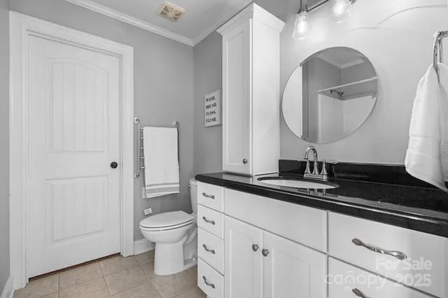a bathroom with a granite countertop toilet a sink and a mirror