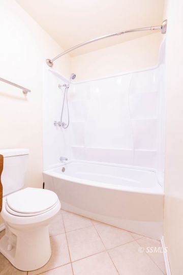 1224 North Inyo Street Ridgecrest, CA 93555 - Photo 17 of 28 a white toilet sitting next to a bath tub and a shower
