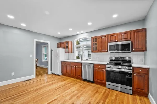 a kitchen with stainless steel appliances granite countertop wooden cabinets a stove top oven a sink and dishwasher