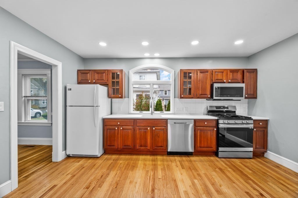 25 Tedesco Street Marblehead, MA 01945 - Photo 6 of 42 a kitchen with stainless steel appliances granite countertop a stove a sink and a refrigerator