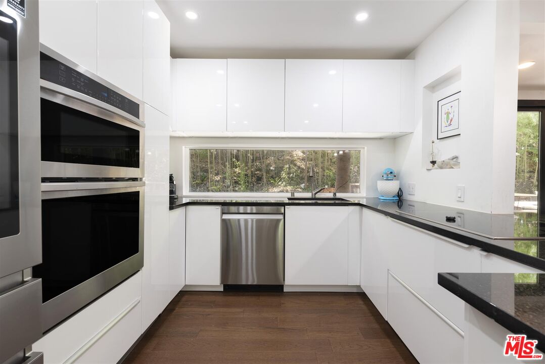 2429 Outpost Drive Los Angeles, CA 90068 - Photo 11 of 29 a kitchen with granite countertop white cabinets and a window