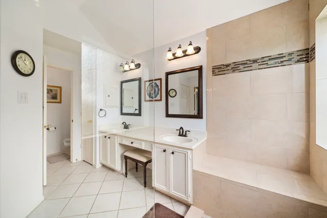 a spacious bathroom with a double vanity sink a mirror and a shower