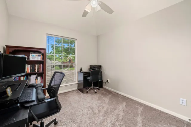 a view of a workspace with furniture and a window