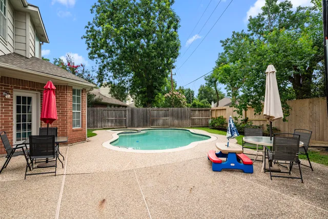 a view of backyard with swimming pool and furniture