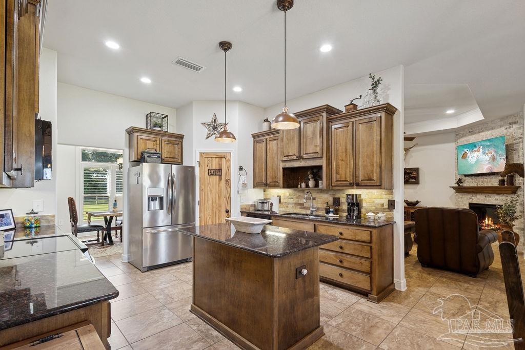 3480 Red Ryder Lane Pace, FL 32571 - Photo 12 of 47 a large kitchen with stainless steel appliances kitchen island granite countertop a refrigerator and a stove top oven