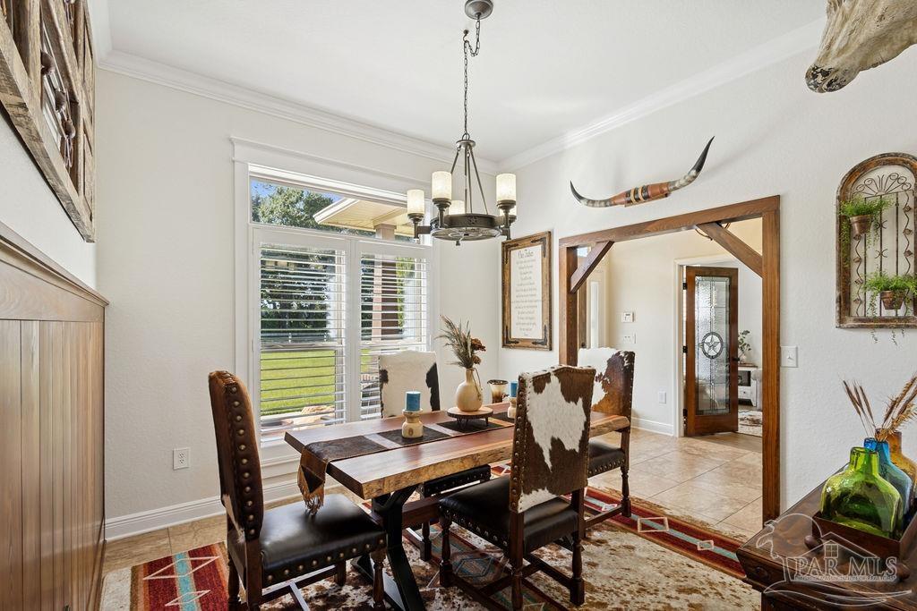 3480 Red Ryder Lane Pace, FL 32571 - Photo 17 of 47 a dining room with furniture a chandelier and a rug