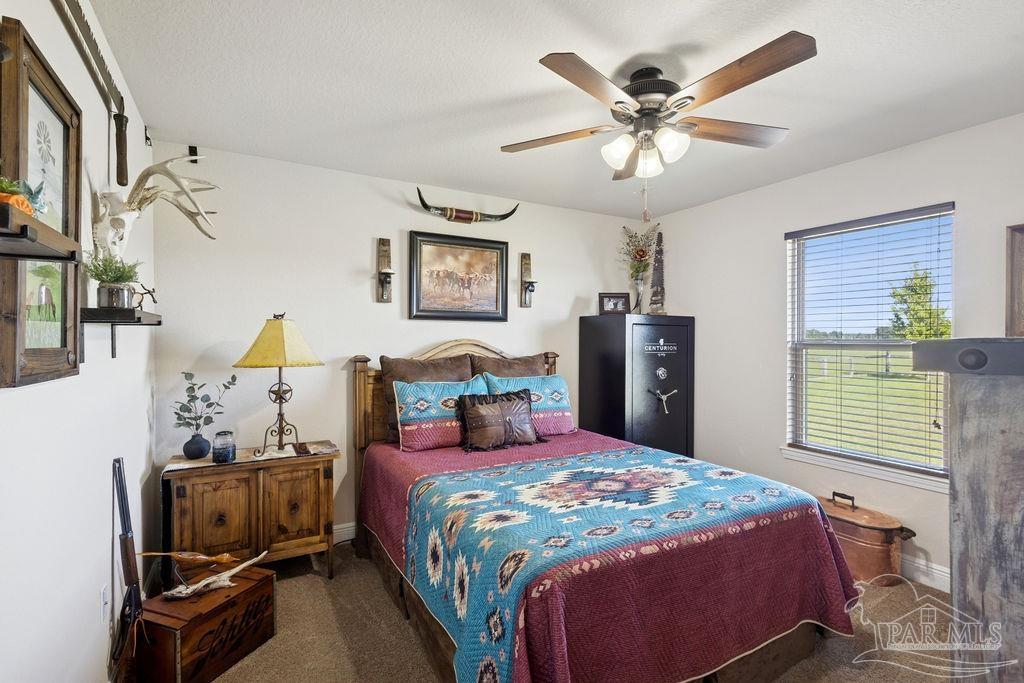 3480 Red Ryder Lane Pace, FL 32571 - Photo 25 of 47 a bedroom with a bed and a chandelier