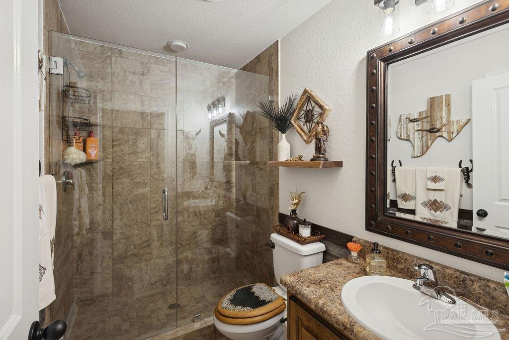 3480 Red Ryder Lane Pace, FL 32571 - Photo 26 of 47 a bathroom with a granite countertop sink toilet and shower