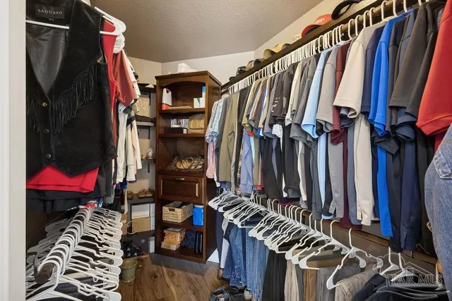 a view of walk in closet with clothes and shoes