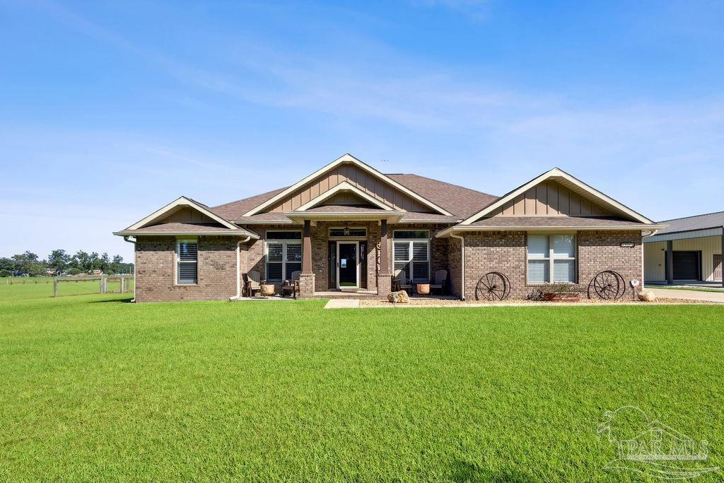 3480 Red Ryder Lane Pace, FL 32571 - Photo 38 of 47 a front view of a house with a garden and yard