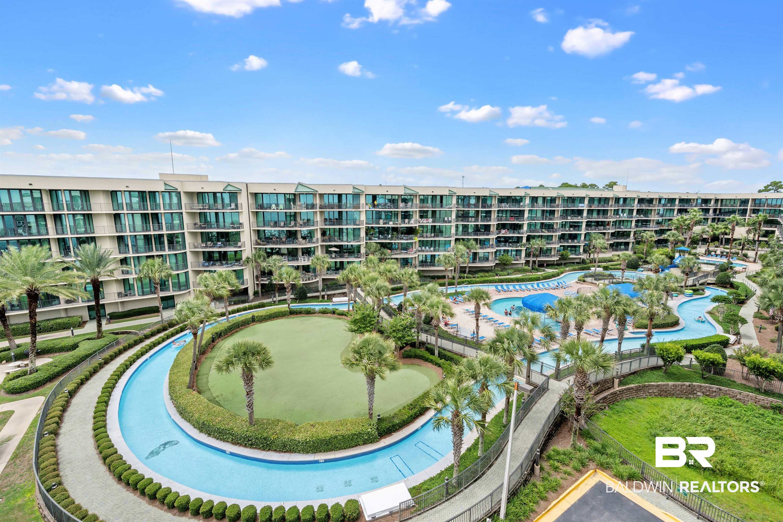 27580 Canal Road, Unit 1421 Orange Beach, AL 36561 - Photo 7 of 40 Expansive resort-style grounds featuring a lazy river, multiple swimming pools, a putting green, and mature palm trees