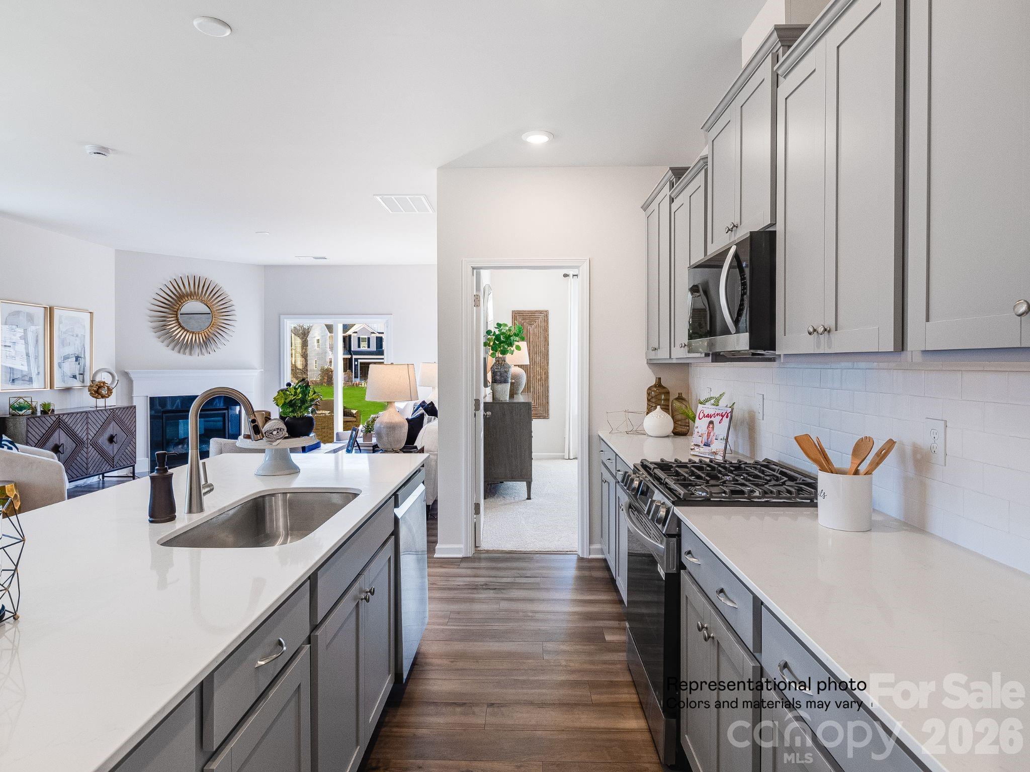 1015 Widgeon Way, Unit 203 Belmont, NC 28012 - Photo 6 of 17 a kitchen with stainless steel appliances granite countertop a sink stove and refrigerator
