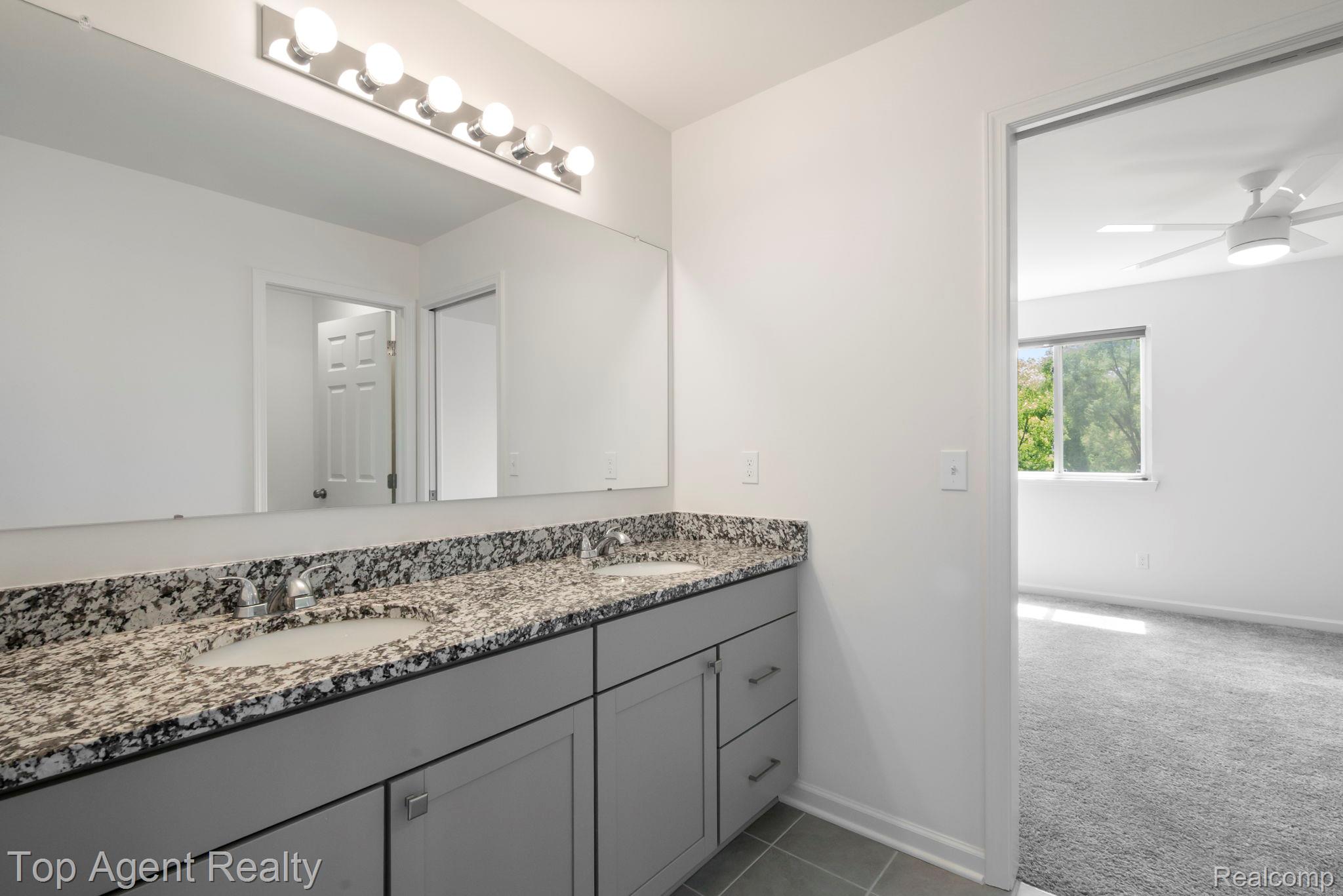 63770 Dequindre Road Washington, MI 48095 - Photo 35 of 61 Dual vanity featuring a speckled countertop, undermount sinks, and grey cabinetry