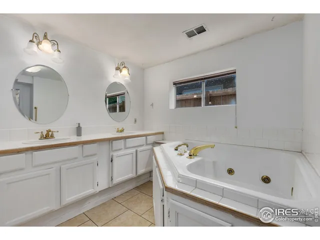 a bathroom with a tub sink and mirror