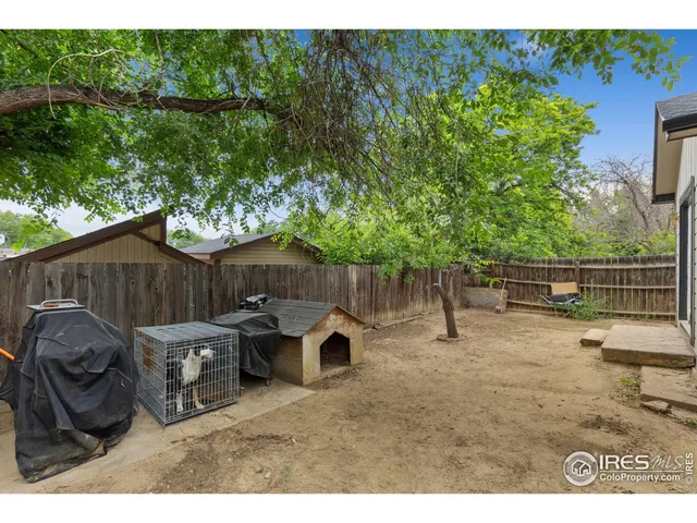 a backyard of a house with barbeque oven and outdoor seating