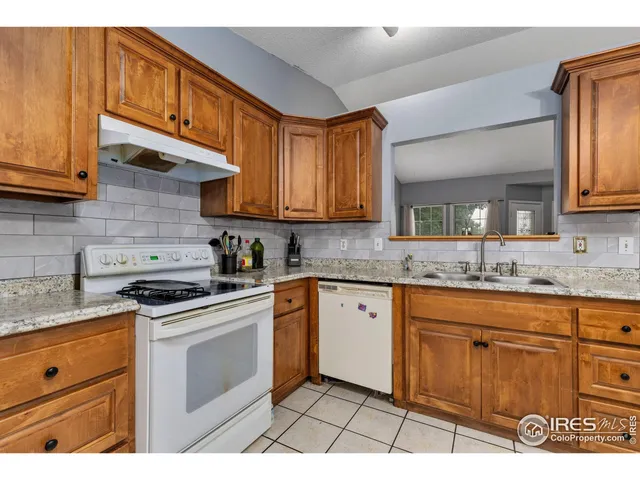 a kitchen with granite countertop a stove sink and cabinets
