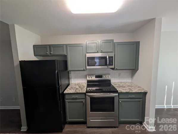 a kitchen with stainless steel appliances granite countertop a refrigerator stove and microwave