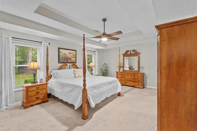 a bedroom with a bed chandelier and a window
