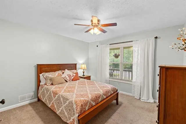 a bedroom with a bed a window and a chandelier